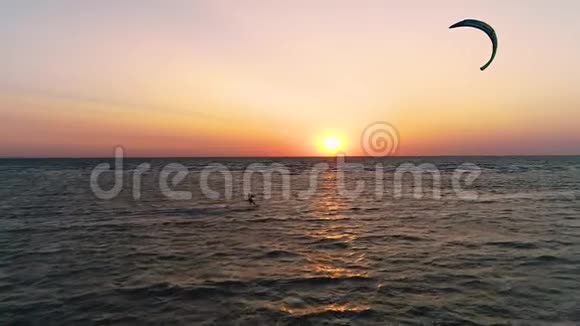 空中拍摄日落时漂浮在海中的一人的剪影有点慢动作视频的预览图