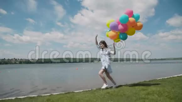 漂亮的小女孩在沙发上用气球奔跑表现出快乐的情绪视频的预览图