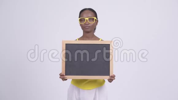 快乐年轻美丽的非洲女人拿着黑板思考视频的预览图
