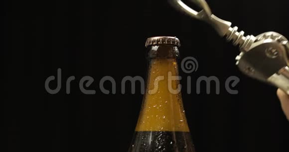 用开瓶器打开冷瓶啤酒凝结水和水滴视频的预览图