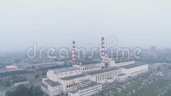 有管道的工业建筑和笼罩在烟雾中的城市空气污染和环境问题视频的预览图