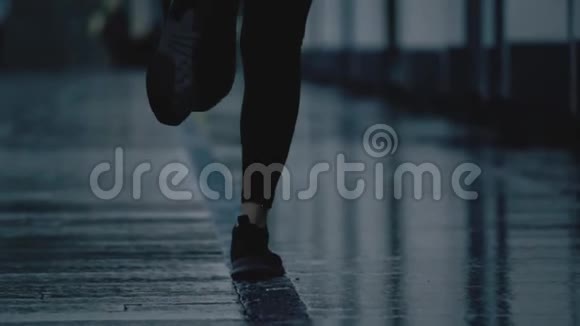 雨后年轻女子脚在潮湿的路面上奔跑的超慢动作长焦镜头视频的预览图
