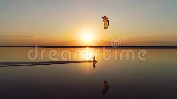 一个孤独的放风筝的人在一个湖上的橙色日落视频的预览图
