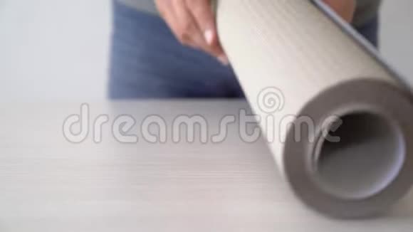 在室内桌上用铅笔和尺子在壁纸卷上贴上男性手标记视频的预览图