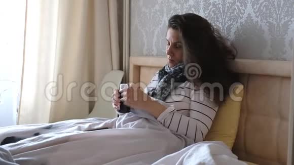 生病的年轻女人躺在床上喝药糖浆视频的预览图
