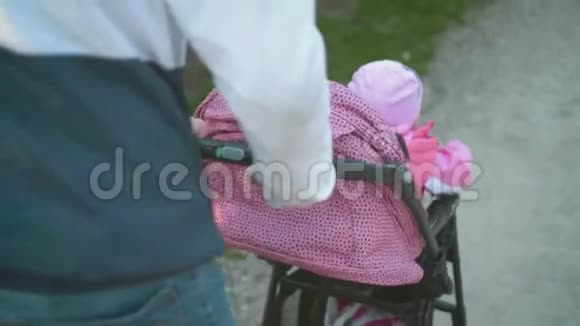 一个年轻人带着小孩在婴儿车里散步视频的预览图