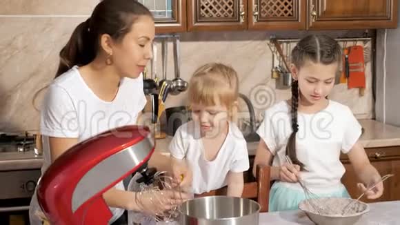 妈妈正在厨房里和她的两个女儿做饭视频的预览图