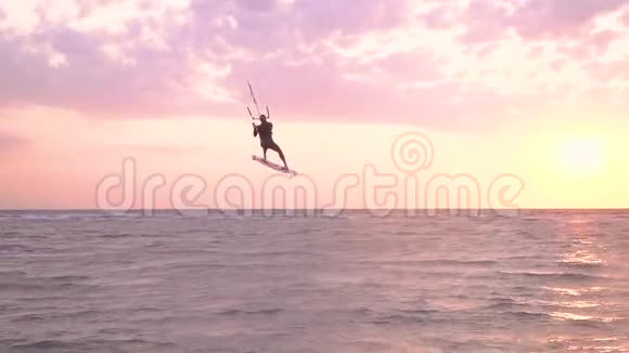 一个放风筝的人在空中表演在浅水中降落动作缓慢视频的预览图