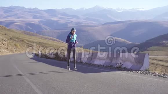 年轻的阿拉伯女人戴着头巾沿着阳光明媚的山路奔跑环顾四周慢悠悠地视频的预览图