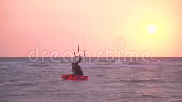 一个穿着潜水服的人拿着一只训练风筝的拖绳站在尾板上视频的预览图