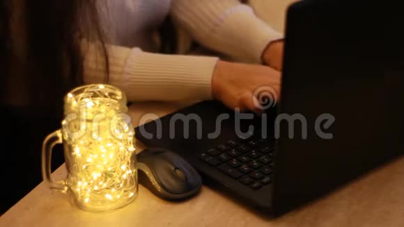 女人的手在家里的办公桌上使用电脑笔记本电脑背景与波克灯视频的预览图