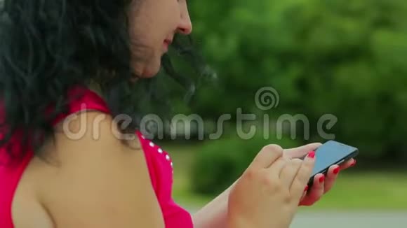 一个穿红色衣服的女人正在手机上打短信特写视频的预览图