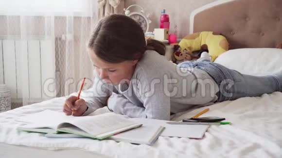 小女孩看书在家里的床上写笔记本视频的预览图