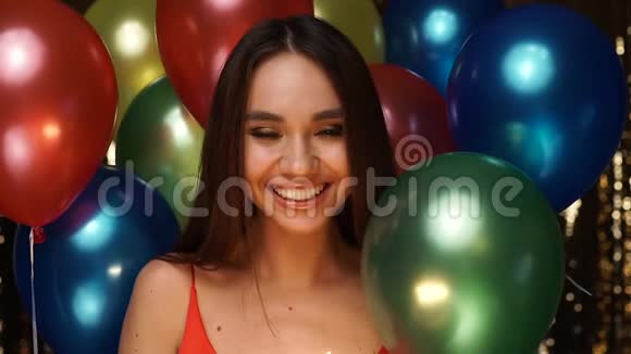 生日派对上拿着气球在蛋糕上吹蜡烛的女人视频的预览图