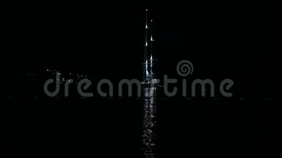 游艇或帆船夜间在海上水面上有灯光反射视频的预览图