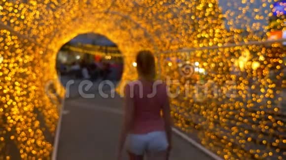 穿着白色短裤的漂亮女孩穿过金色的灯光视频的预览图