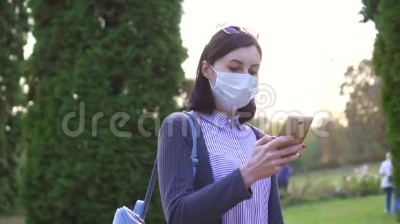 戴着医用防护面罩的女孩走过去用电话慢着视频的预览图