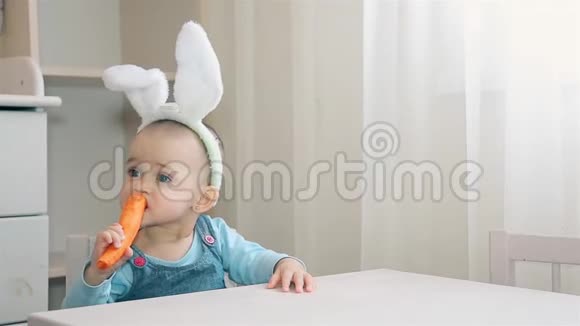 一个学龄前儿童头上戴着兔子耳朵坐在托儿所里嚼着橘子胡萝卜视频的预览图
