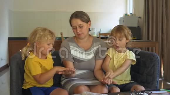 一名教师一名家庭教师一位老师或妈妈和小女孩和男孩在桌子上家庭教育概念视频的预览图