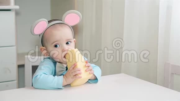 一个穿白桌子吃有洞的黄色奶酪的小孩视频的预览图
