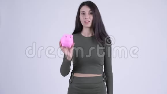 年轻有压力的女人拿着储蓄罐竖起大拇指视频的预览图
