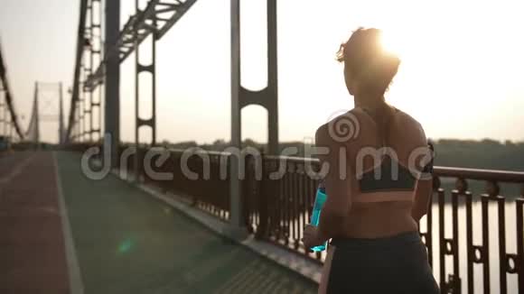 在桥上行走的高级跑步者看着摄像机视频的预览图