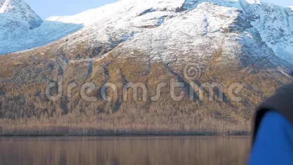 一个人一个中年运动员在山里迎接黎明他在智能手机上拍摄美丽的景色视频的预览图