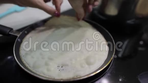 烹饪自制煎饼的过程女人在煎锅里烤煎饼视频的预览图
