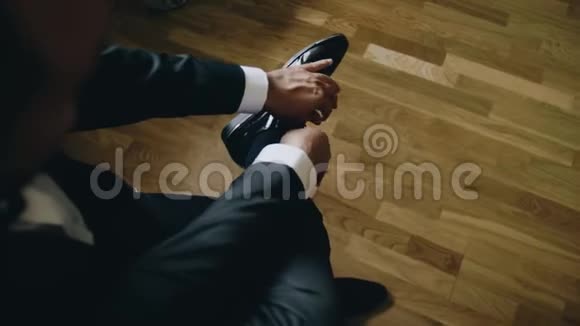 那个人把脚放在腿上把鞋带系在鞋上视频的预览图
