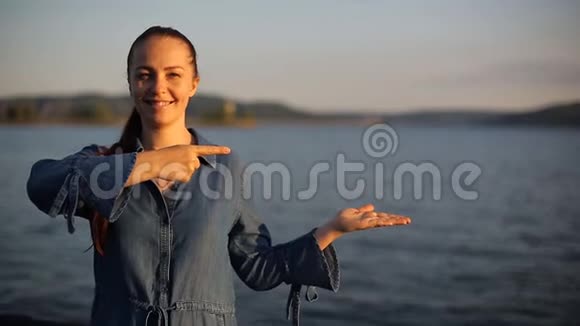 一位年轻的白人妇女举起手掌用食指指着她文本放置位置视频的预览图