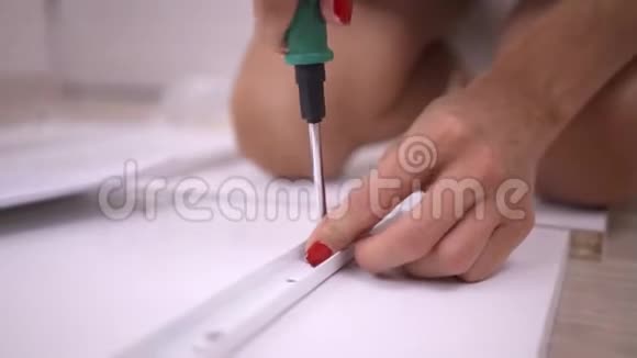 硬手收盒特写一个女人正在用螺丝刀组装一个白色的木柜视频的预览图