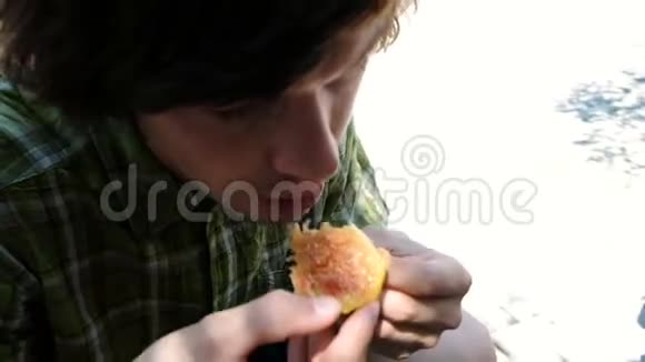 男人咬和吃成熟的无花果在一个夏季公园特写视频的预览图
