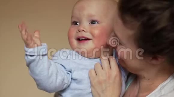 妈妈抱着他的儿子他挥舞着双手微笑着母亲节视频的预览图