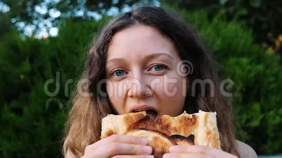 美丽的年轻女子高兴地咬下一块卡沙普里面包和奶酪特写慢动作视频的预览图