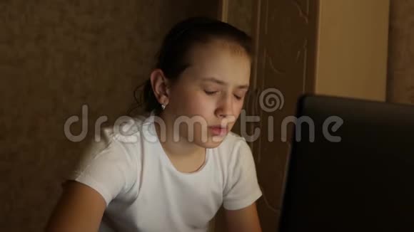 学生女孩晚上在家里用笔记本电脑工作疲惫的年轻女孩在电脑上工作视频的预览图