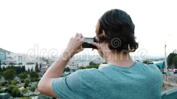 游客正在从智能手机上的观景台上拍摄城市中的一个历史地方视频的预览图