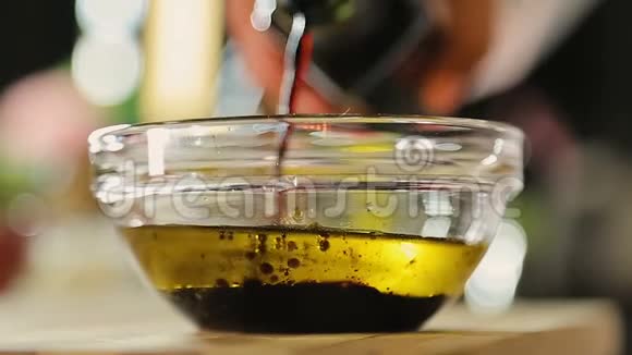 厨师在桌上的玻璃碗中加入深色意大利醋视频的预览图