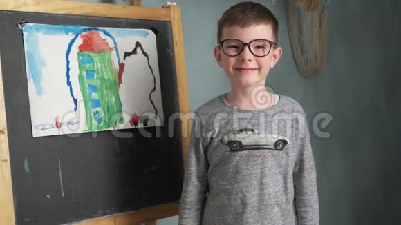 男孩站在他的画旁边视频的预览图