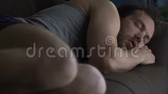 醉汉穿着内衣睡在客厅沙发上懒散的单身生活方式视频的预览图