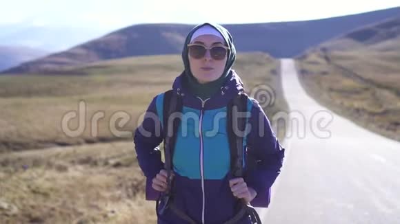 穆斯林游客的肖像带着旅游背包和太阳镜在山上慢莫视频的预览图