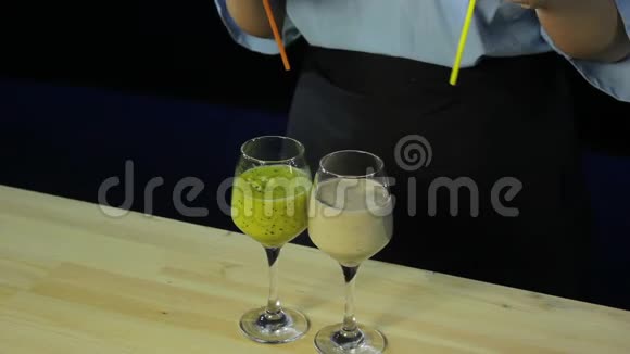 一位女士将鸡尾酒管插入带有水果奶昔的眼镜中视频的预览图
