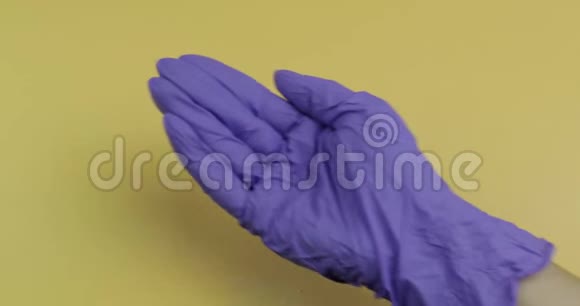 穿着蓝色医用手套的手把大量的药丸放进另一只手视频的预览图