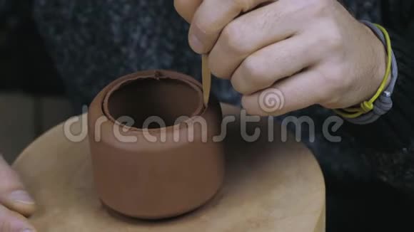 陶工用木刀从宜兴陶土中取出多余的陶土手工陶土茶壶用于茶道棕色视频的预览图