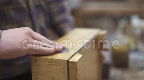 用一块破布把一个轻木制的木架子打磨得紧紧的视频的预览图