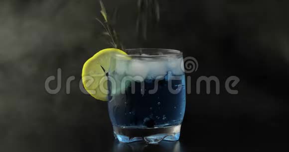 在杯子里加入黑醋栗和汽水柠檬水蓝色鸡尾酒视频的预览图