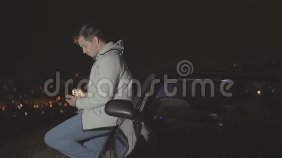 夜城背景下的男性司机使用智能手机视频的预览图
