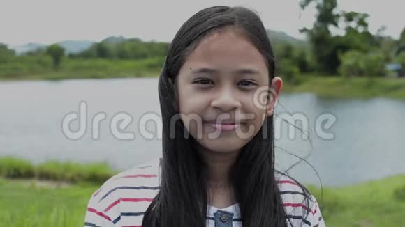 特写可爱的亚洲女孩在田野里微笑的肖像视频的预览图