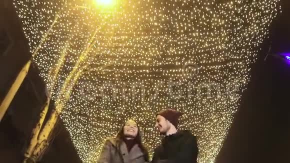 带着圣诞装饰穿过街道的夫妇视频的预览图