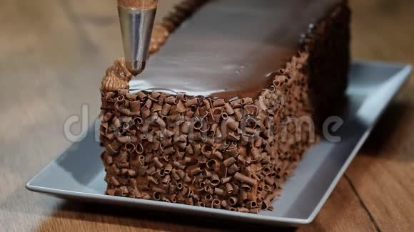 糖果师装饰蛋糕并用黄油霜覆盖它巧克力海绵蛋糕加黄油奶油视频的预览图