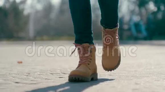 近距离低角度跟踪拍摄的无法辨认的女人穿着靴子向前走视频的预览图